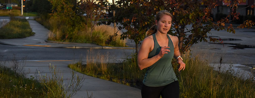 Female member runs outdoors during WOD at CrossFit Alaska.