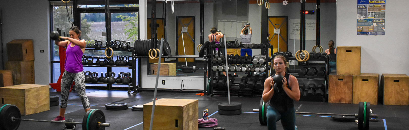 Two female members work out with kettlebells at CrossFit Alaska.