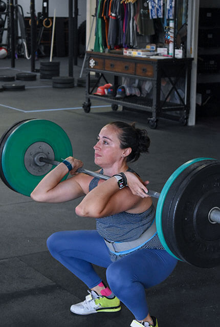 Female member power cleans at CrossFit Alaska.
